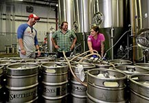 Jason Ginos (l) and Micah Niebauer of Southern Pines Brewing with Angel Martinez.