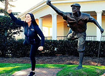 Lisa Vlooswyk poses with Payne Stewart Statue.